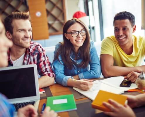 Group of Smiling students talking to each other symbolising student exchange