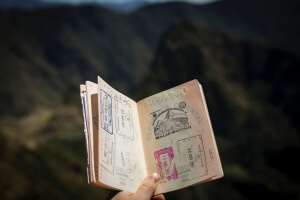 Person holding a passport opened showing many visa stamps. Australian visa concept.