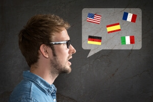 A man with glasses speaking different languages. Learn a foreign language when moving abroad alone.