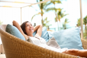 Sofa Woman relaxing enjoying luxury lifestyle outdoor day dreaming and thinking looking happy up smiling cheerful. Beautiful young multicultural Asian Caucasian female model in her 20s.