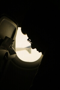 Homesick person on a plane moving abroad alone