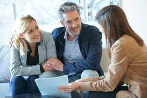 Real-estate agent reading terms of contract to clients looking to buy a property abroad