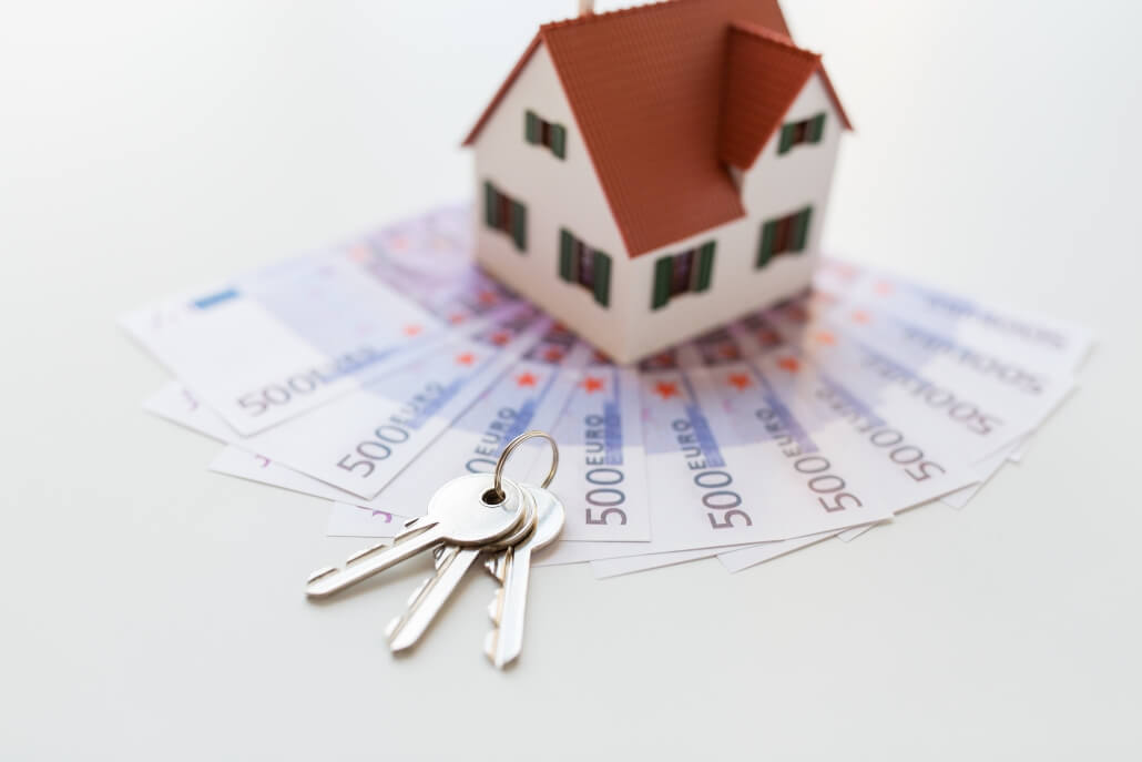 mortgage, investment, real estate and property concept - close up of home model, money and house keys