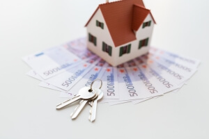 mortgage, investment, real estate and property concept - close up of home model, money and house keys