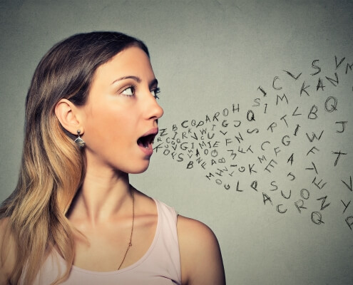 Woman talking with alphabet letters coming out of her mouth. Communication, information. Learning a foreign language when moving abroad.