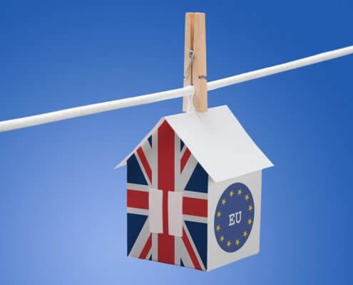 Britain flag and EU flag painted on a paper house hanging on a rope, symbolising Brexit vote impact on property purchase