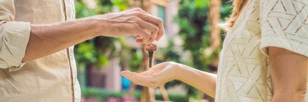 Real estate agent giving keys to apartment owner, buying selling property business. Close up of male hand taking house key from realtor. Mortgage for purchasing flat, getting access to own home after a real estate investment