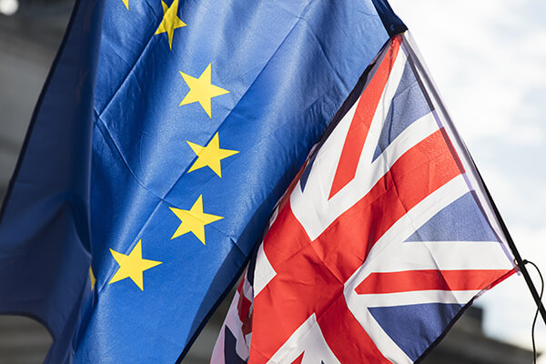 European union and British Union jack flags flying together. Brexit concept - Halo Financial
