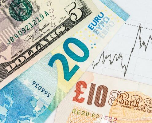 Euro Dollar and Pound banknotes with a chart in the background symbolising economic data from UK Euro and US concept of recent events affecting currency markets