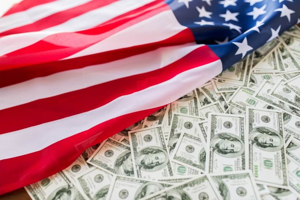 US Dollar banknotes covered by USA flag