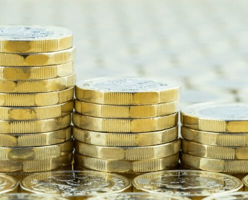 British money, three pound coins descending stacks. New silver and gold coins introduced in 2017.