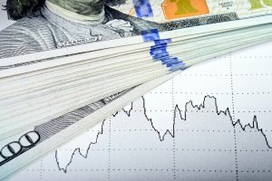 Stock market chart and 100 US Dollars banknote.