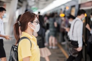 young Asian woman wearing protection mask against Novel coronavirus (Covid-19) or Wuhan coronavirus at public train station,is a contagious virus that causes respiratory infection.