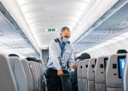 man helping passengers in a flight