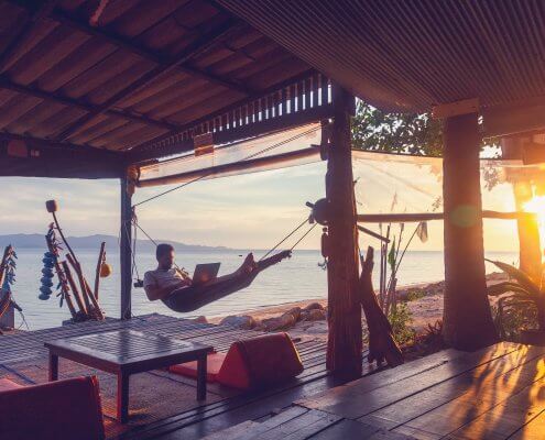 man with in a hammock with a laptop