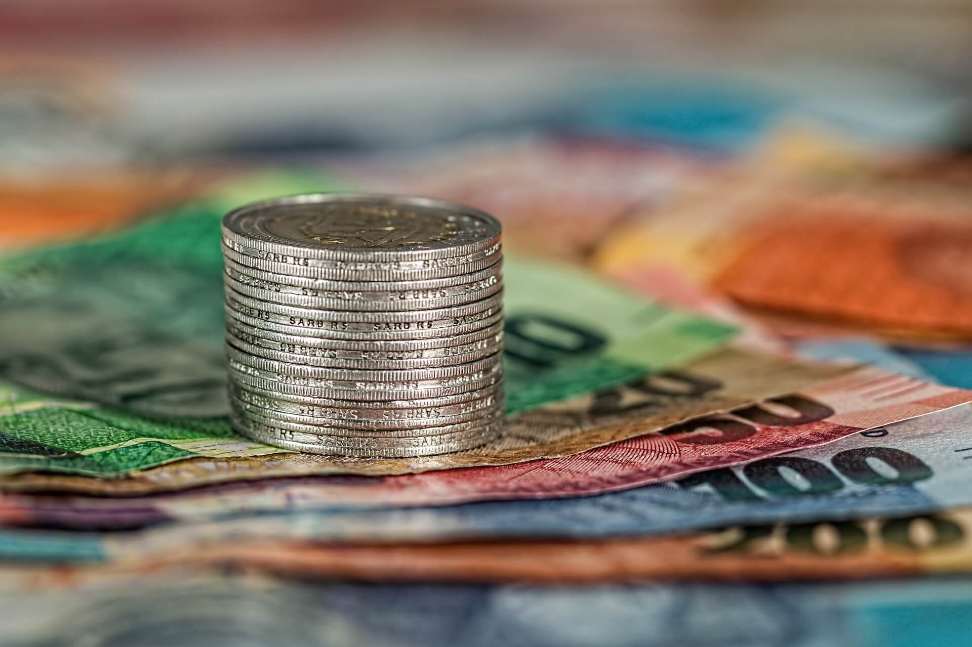 stack of coins on top of euro banknotes