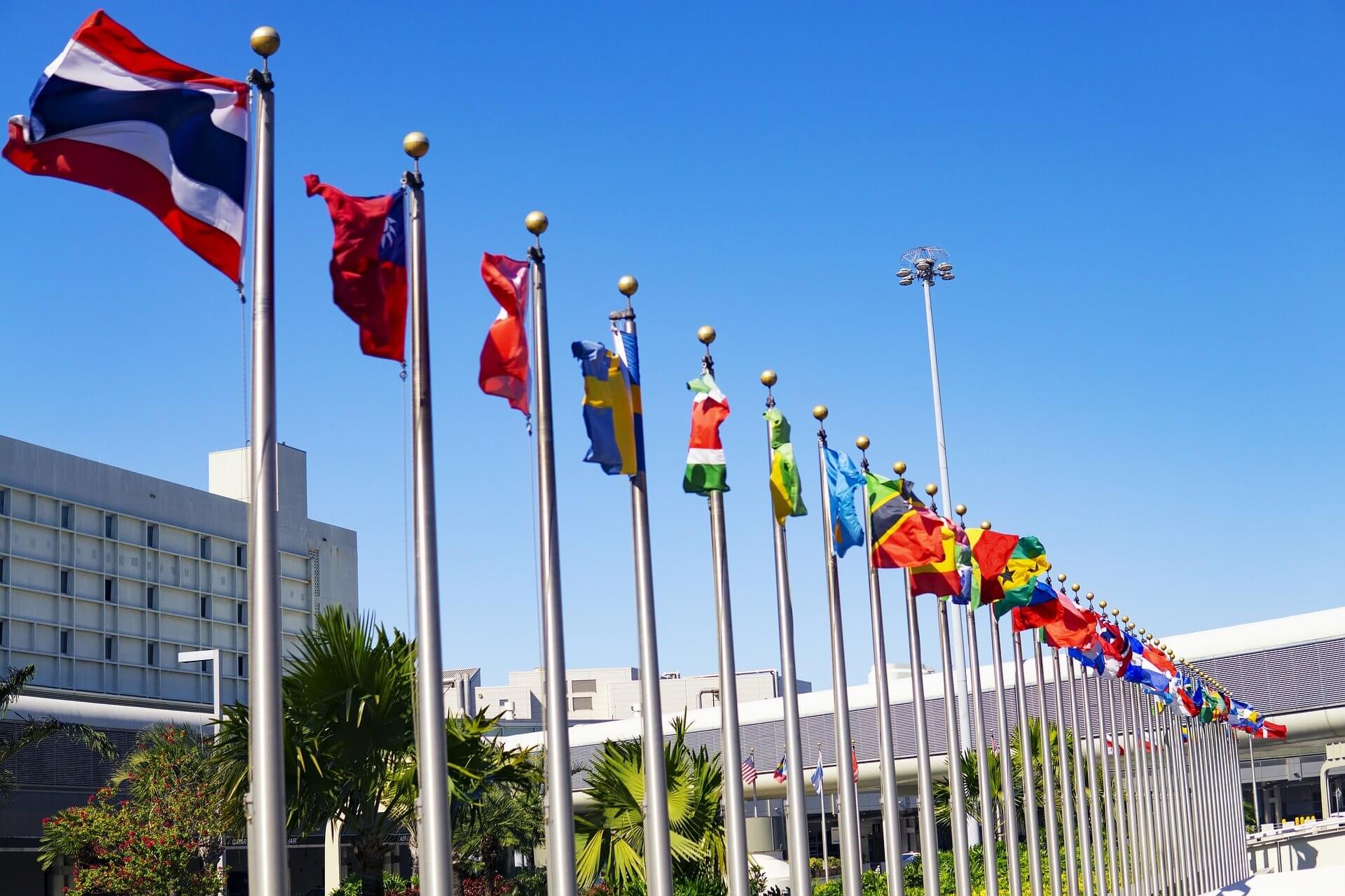 flags from various nations raised in a straight line