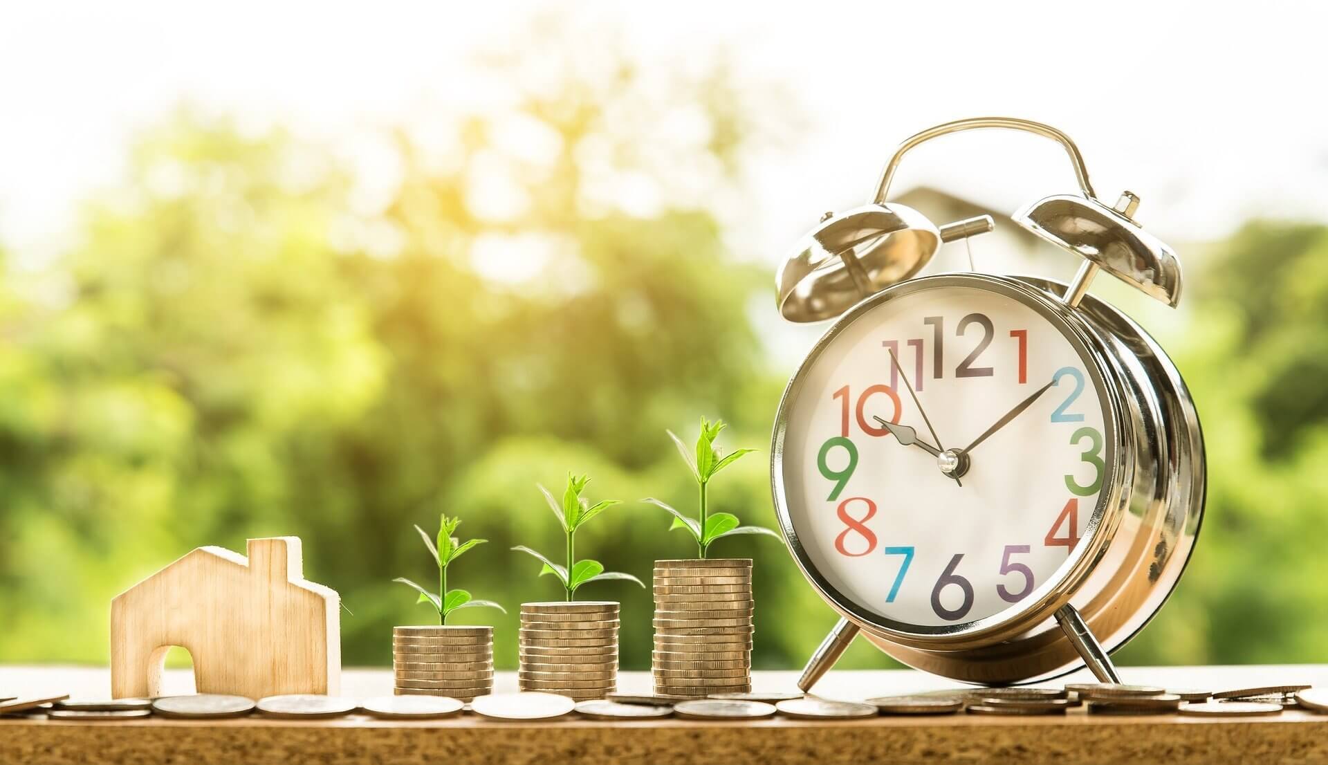 a stack of coins next to a clock