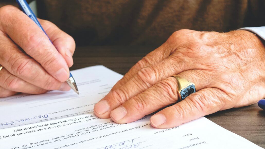 a man signing on bank account opening form