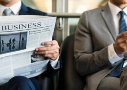 Business Men Sit Read Newspaper